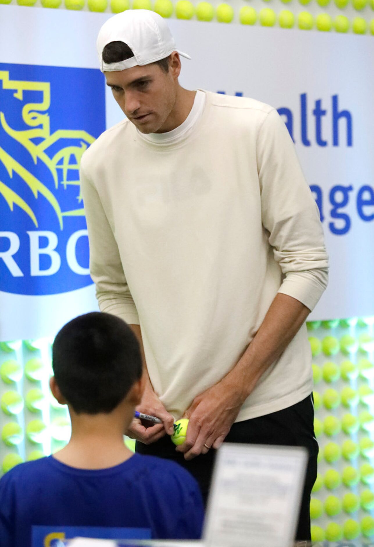 Local pro John Isner signs an autograph before the match as Frances Tiafoe played Denis...