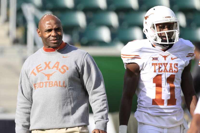 Texas Head Coach Charlie Strong watches his players during the warm-up before the kick-off...