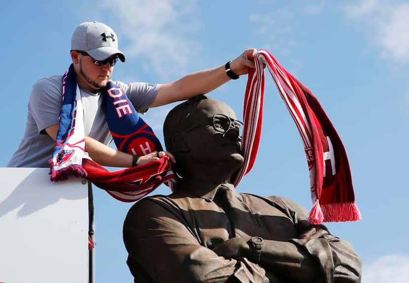 Darien Walker places a scarf on the Lamar Hunt statue before the game against Toronto FC at...