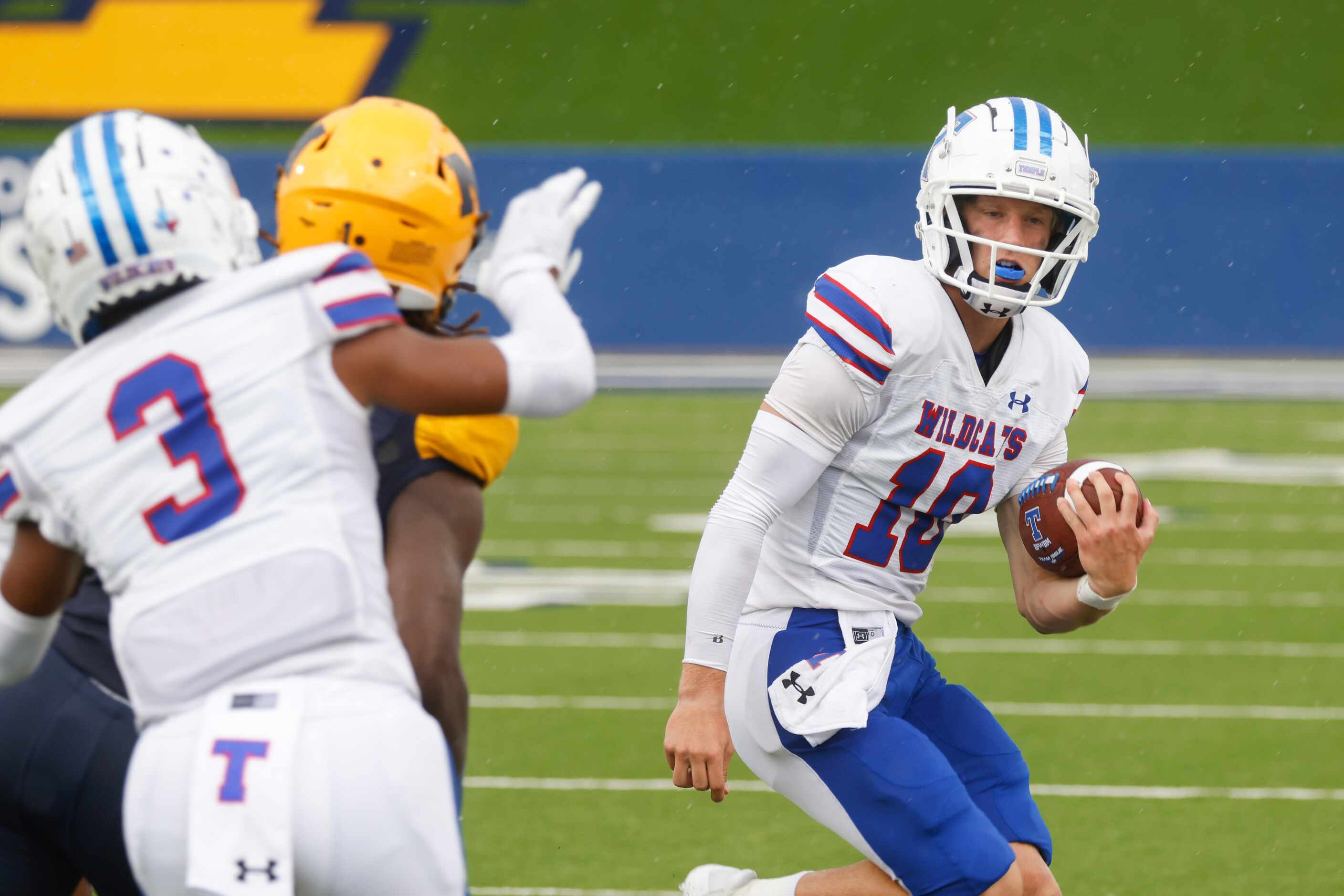 Temple High’s QB Reese Rumfield (10) runs for a yardage past McKinney High’s defense line...