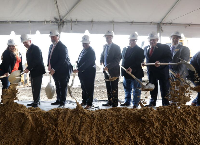 Community leaders and project VIPs break ground during an event at the new Collin College...