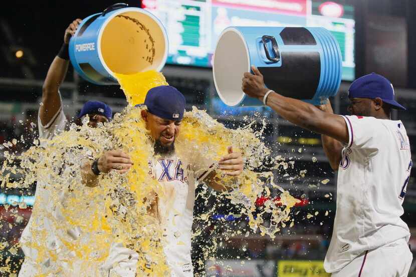 Texas Rangers' Elvis Andrus, left, and Hanser Alberto, right, douse Rougned Odor after...