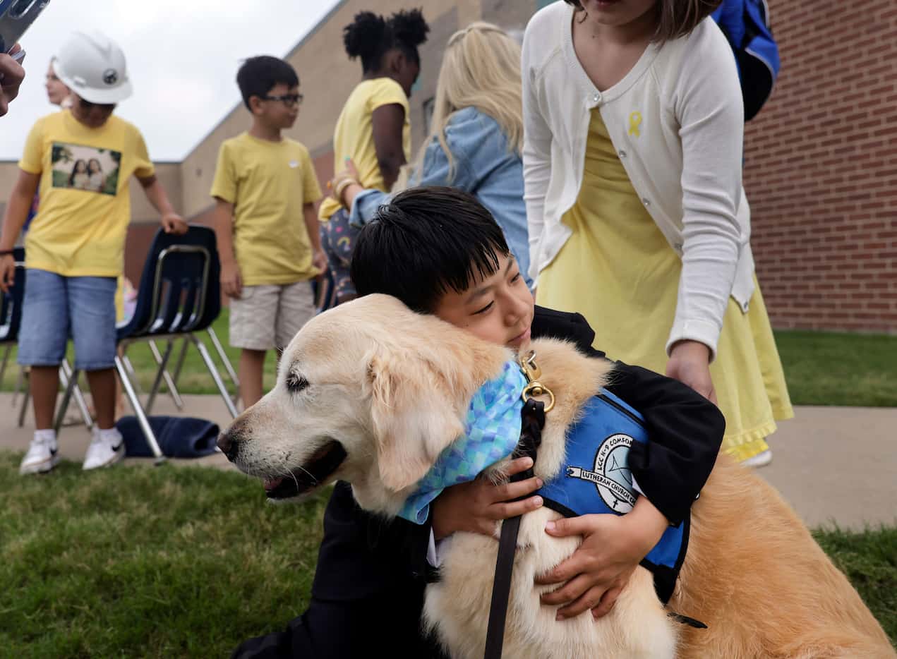 Third grader Eric Lee hugs comfort dog Phoebe from St. Paul Lutheran Church in Fort Worth...