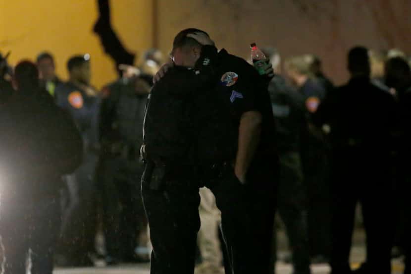 Police officers console each other outside the emergency room at the Denton Regional Medical...