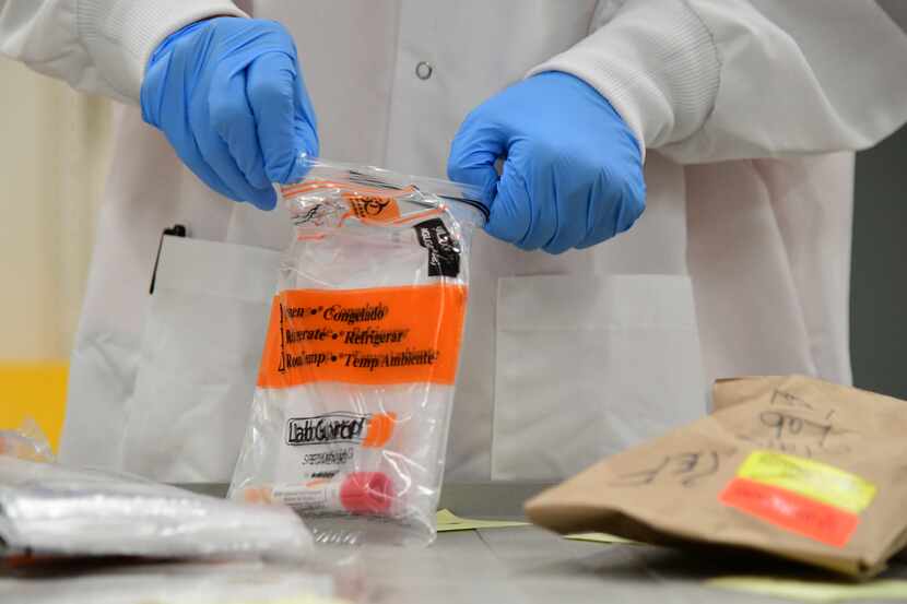 David Storey processes samples for a coronavirus test at the Colorado Department of Public...