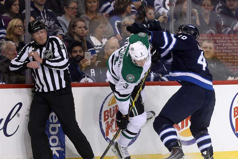 Dallas Stars' John Klingberg (3) is hit hard into the boards by his brother, Winnipeg Jets'...