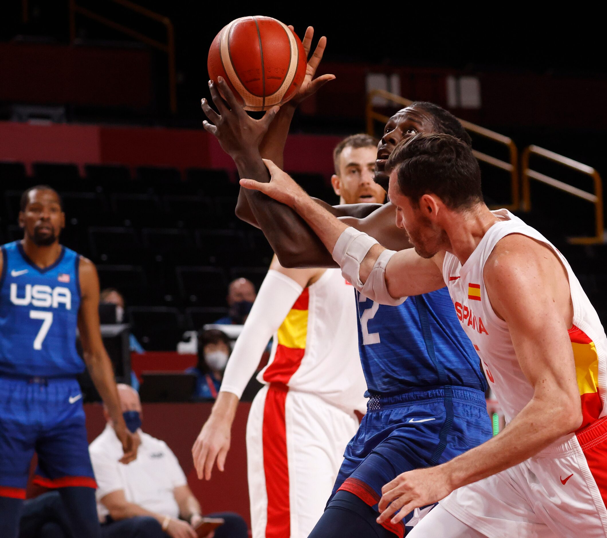 USA’s Jrue Holiday (12) is fouled by Spain’s Rudy Fernandez (5) as he attempts a layup...