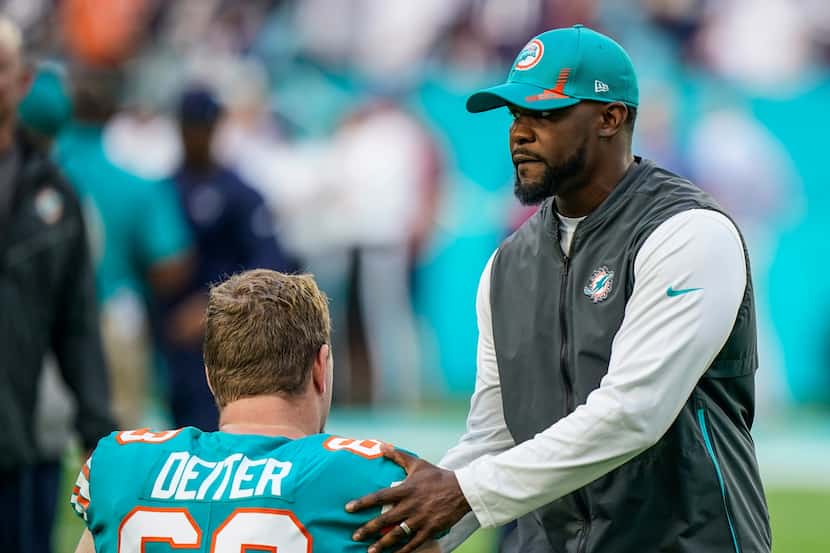 FILE - Miami Dolphins head coach Brian Flores talks with Miami Dolphins center Michael...