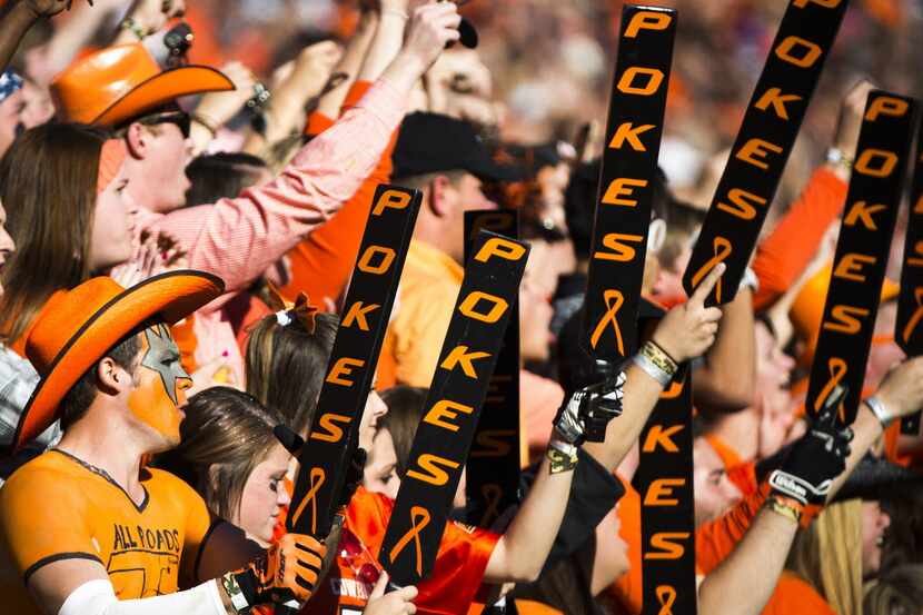 Oklahoma State fans cheer as their team takes the field before an NCAA football game against...