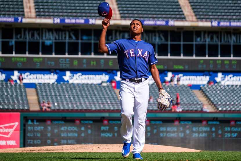 Texas Rangers pitcher Jose Leclerc tips his cap as he leaves the mound after retiring the...