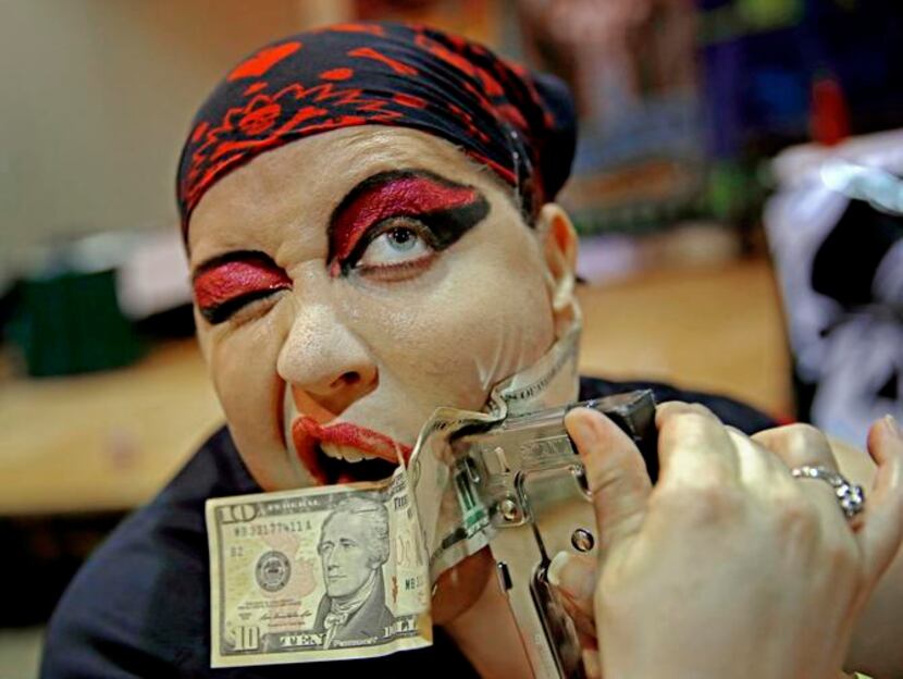 
Sandra “BZ” has cash stapled to her face as part of a performance by the Captain’s Sideshow...