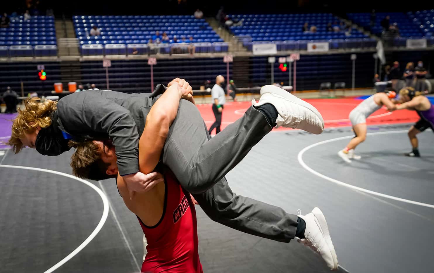 Mason Ding of Carrollton Creekview lifts coach Sean Kitchen in celebration after defeating...