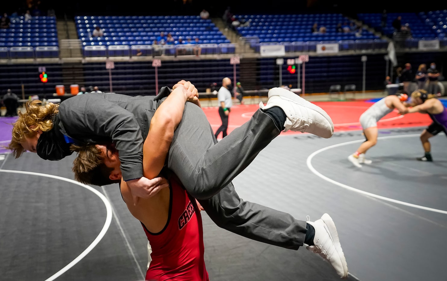 Mason Ding of Carrollton Creekview lifts coach Sean Kitchen in celebration after defeating...