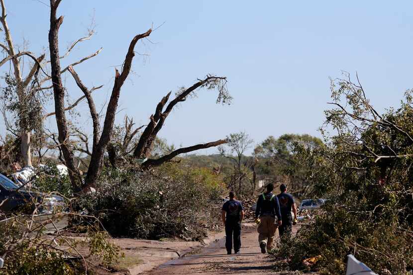 Firefighters walked through a neighborhood damaged by a tornado in Dallas last October.