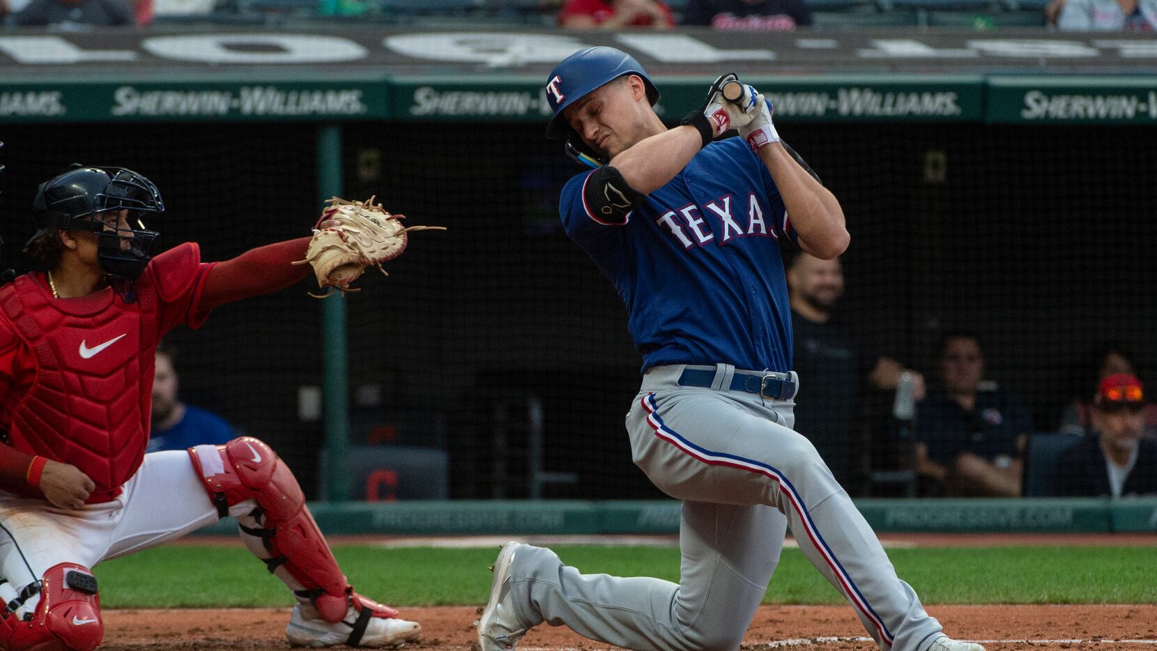 Texas Rangers' Corey Seager, right, ducks away from an inside pitch by Cleveland Guardians...