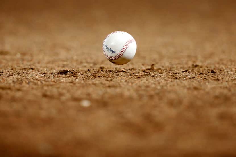 A foul ball bounces in front of the Texas Rangers dugout during a game against the Houston...