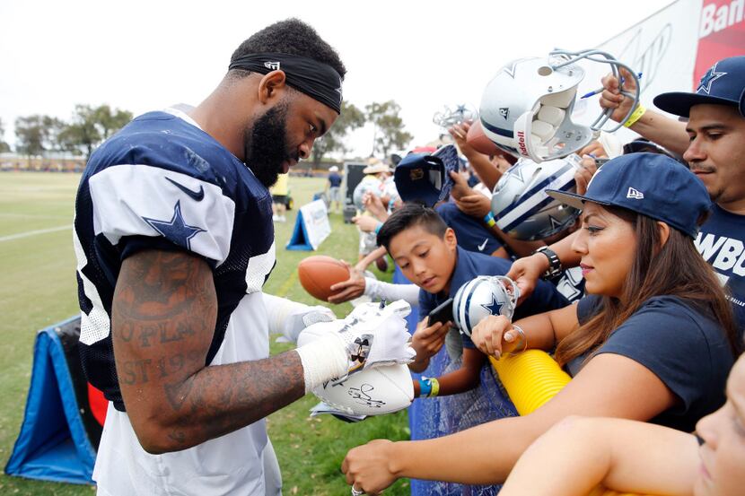 Dallas Cowboys defensive end Damontre Moore (58) signs a football for a fan after the...