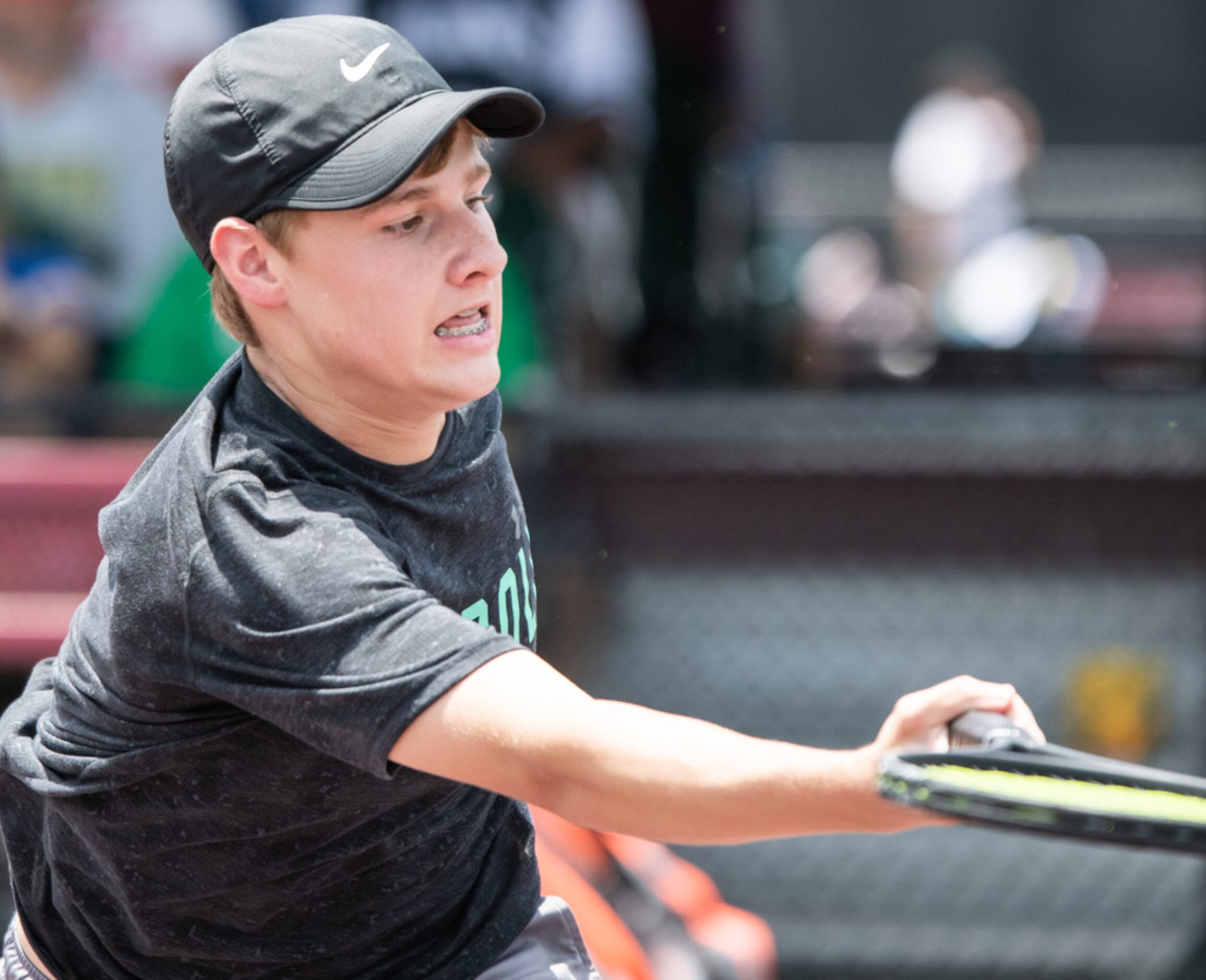 Southlake Carroll's Drake Ferri returns the ball in a doubles match with teammate Kelly Kunz...