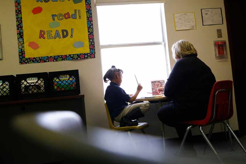 Beverly Funk, a First United Methodist Church volunteer, helps a student learn to read at...