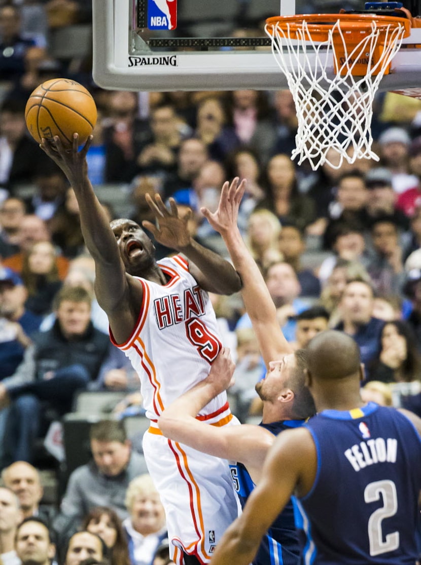 Miami Heat forward Luol Deng (9) puts up a shot over Dallas Mavericks forward Chandler...