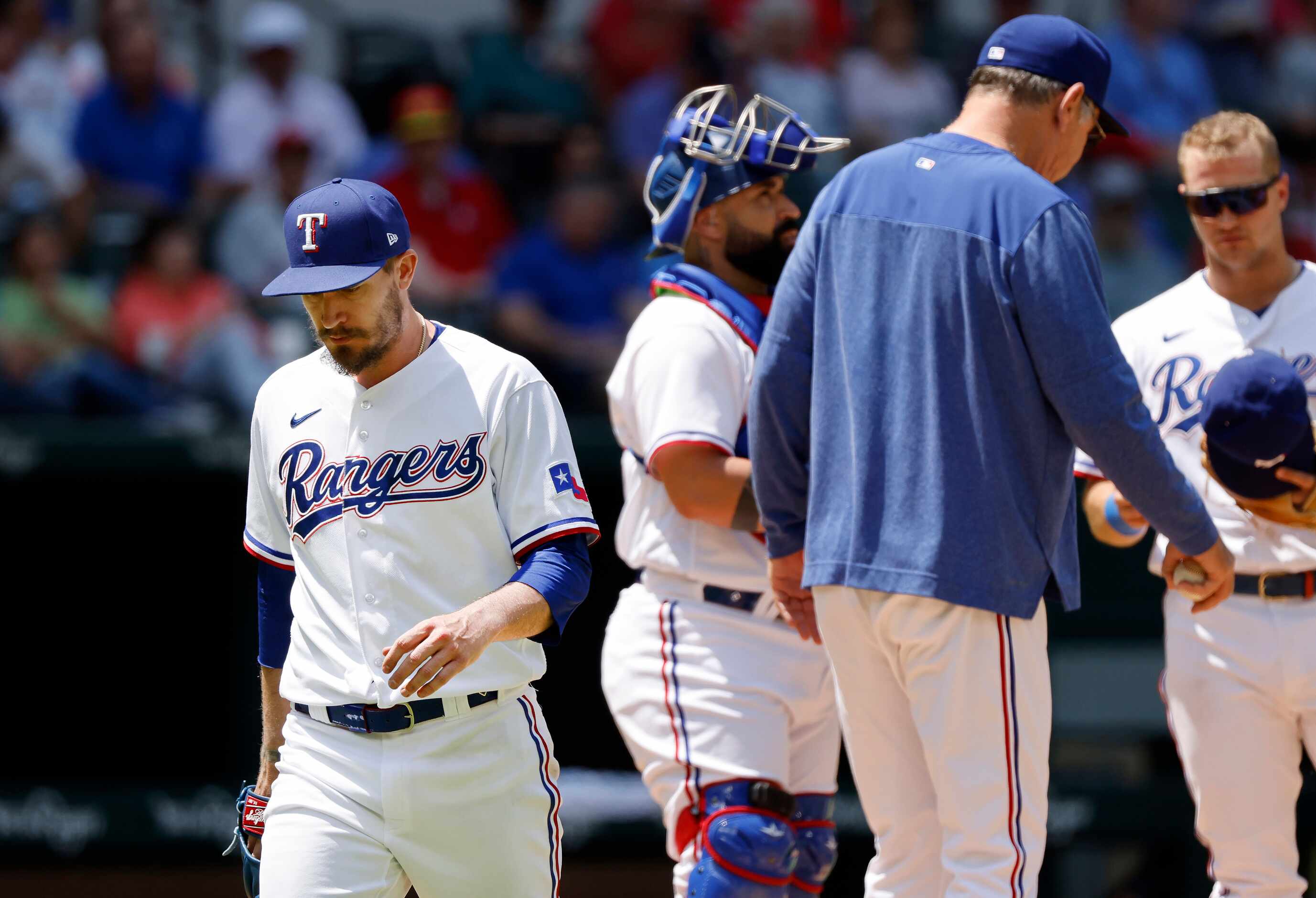 Texas Rangers starting pitcher Andrew Heaney (left) heads to the dugout after being pulled...