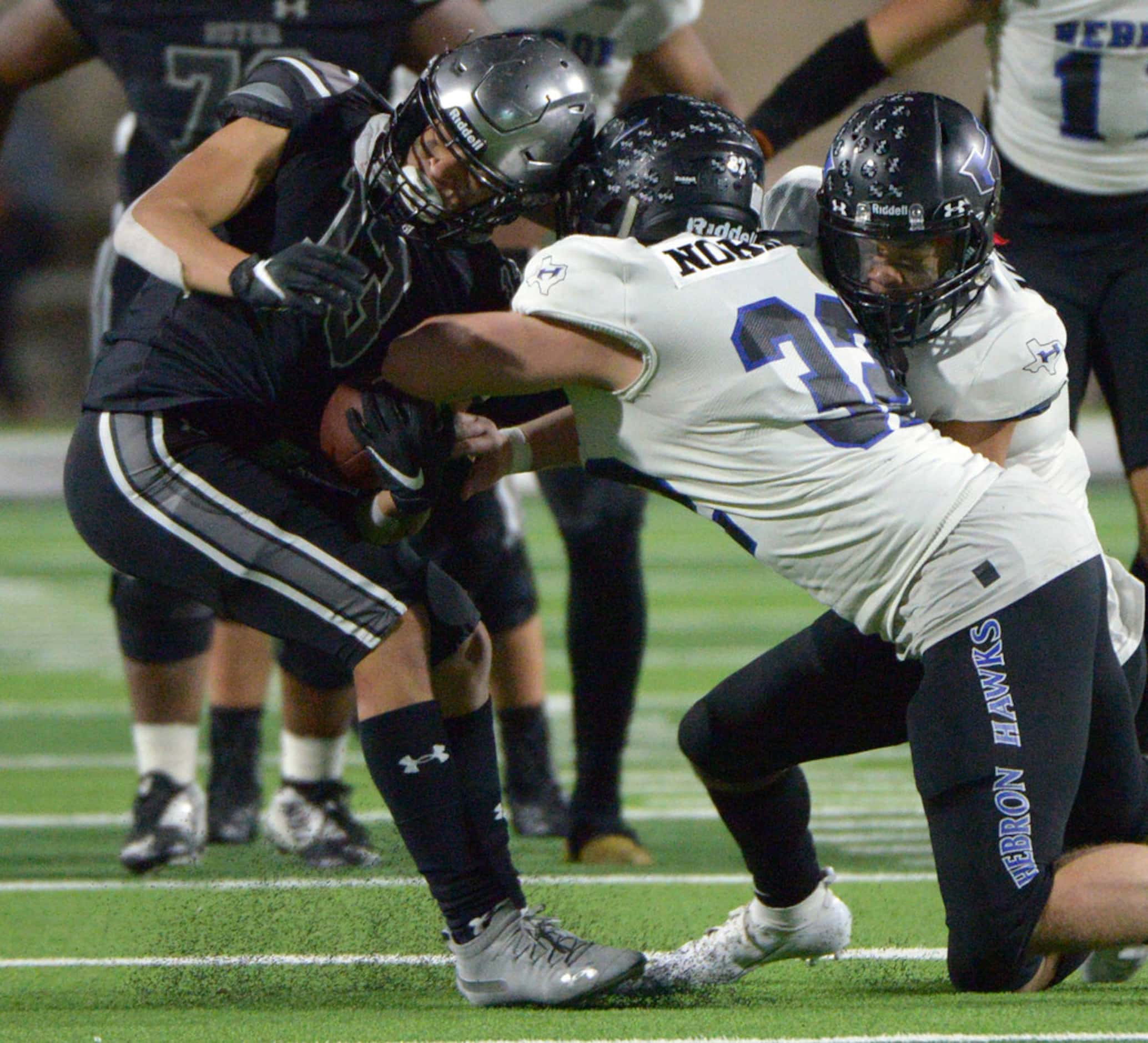 Guyer's Brandon Deleon (13) holds on for the catch while being hit by Hebron's Carter Norrie...