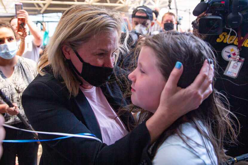 Dallas salon owner Shelley Luther, center, hugs Savannah Holt, 10, of Garland, after Luther...