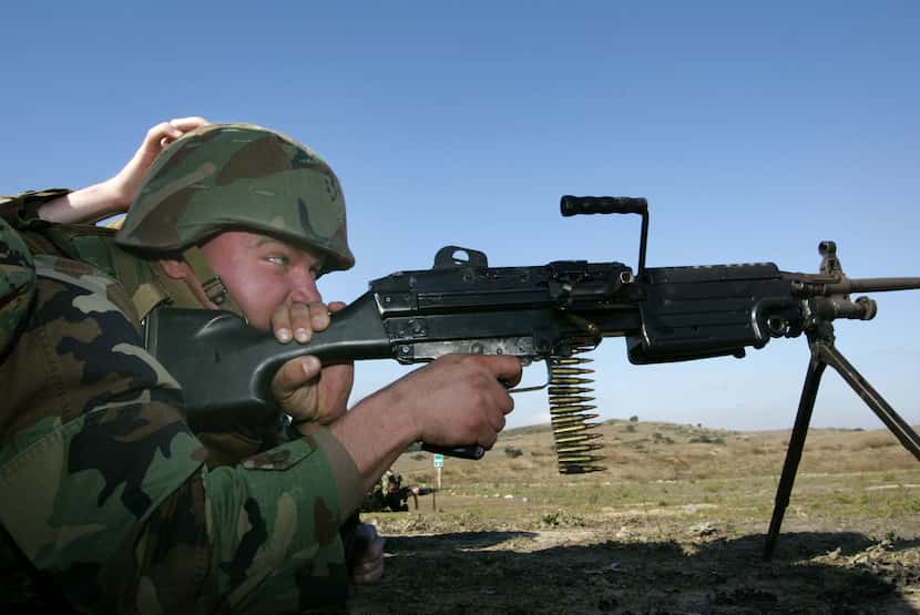 A U.S. Marine reservist fires an M249 SAW (Squad Automatic Weapon) machine gun during combat...