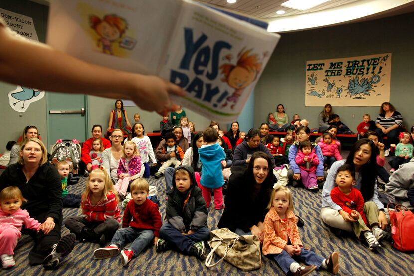 Frisco Public Library assistant Lisa Kilian reads "Yes Day!" to a group of toddlers during...