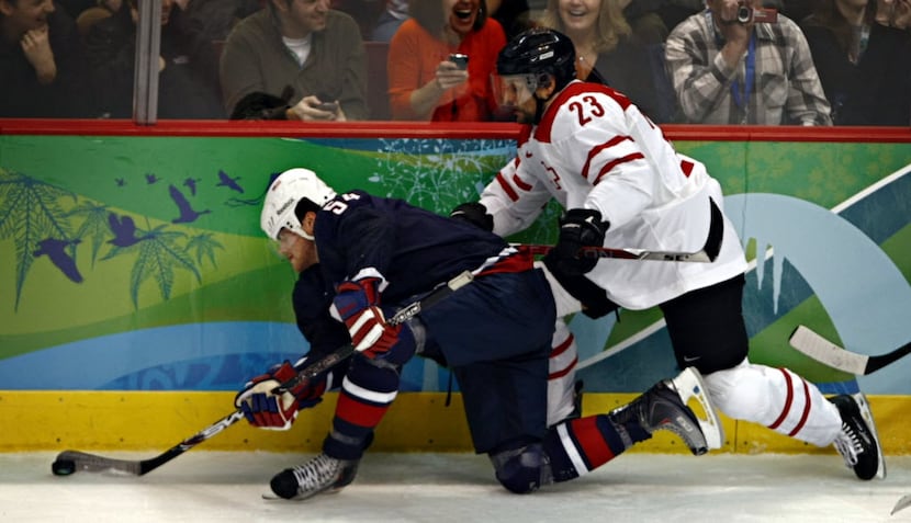 02/16/2010 -- The United States' Bobby Ryan (54) fights off Switzerland's Thierry Paterlini...