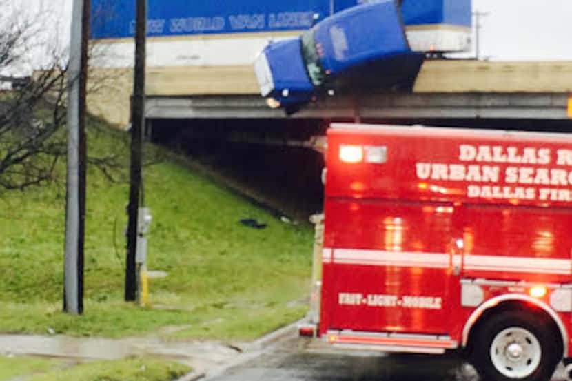 The cab of an 18-wheeler dangling over the edge of IH-35E and Saner Avenue. (Dallas...