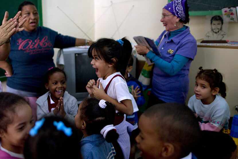 Cuban students and teachers celebrate Wednesday after listening to a live, nationally...