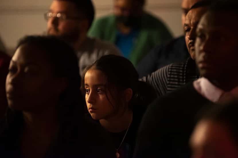 Kayla Aguero, 8, center, sits alongside her dad Raudel Parra, right, as they and other Joppa...