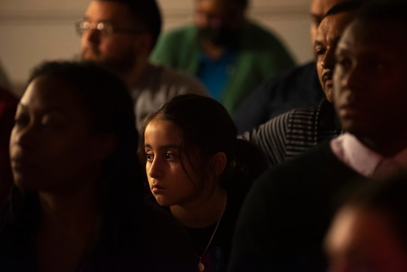 Kayla Aguero, 8, center, sits alongside her dad Raudel Parra, right, as they and other Joppa...