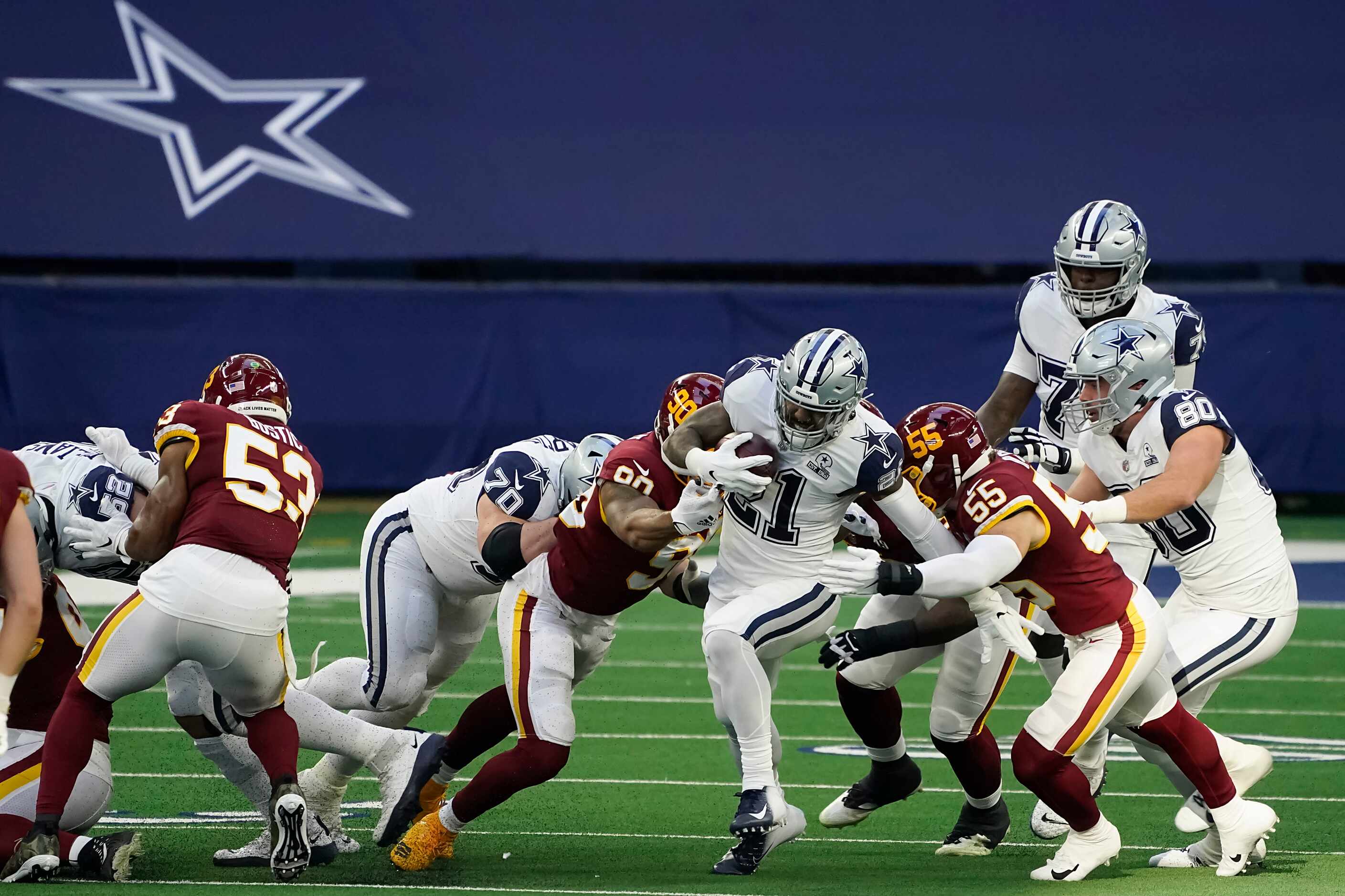 Dallas Cowboys running back Ezekiel Elliott (21) is brought down by Washington Football Team...