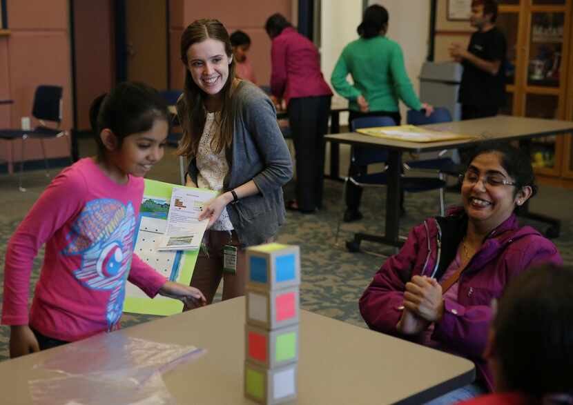 Librarian Laura Hargrove  (center) and Aarushi Sudhakar, 9, watch as Aarushi’s mother, Arati...