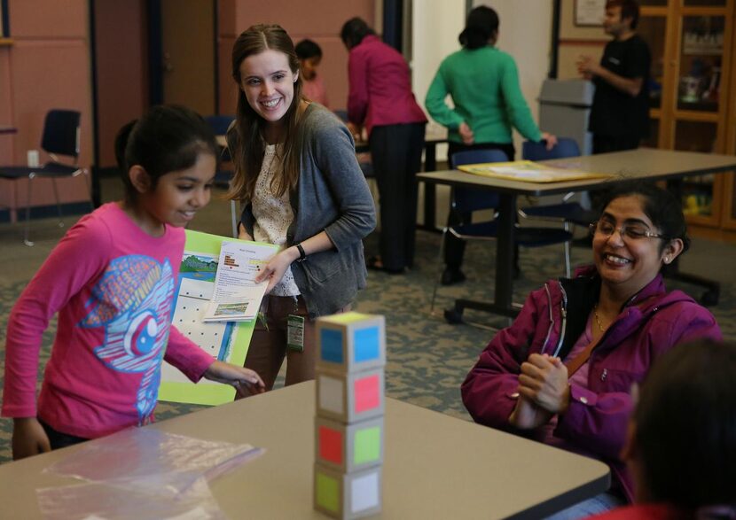 Librarian Laura Hargrove  (center) and Aarushi Sudhakar, 9, watch as Aarushi’s mother, Arati...