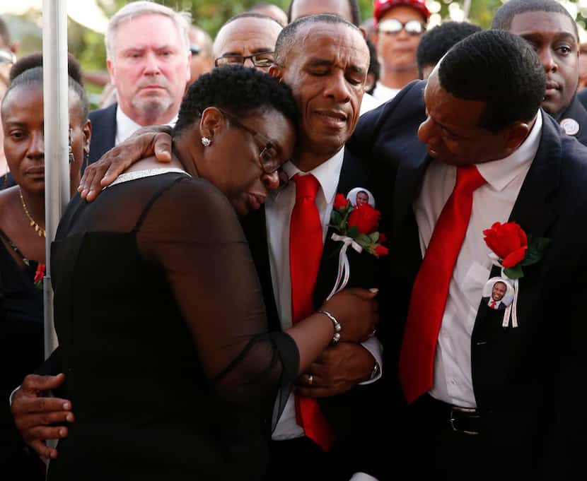 Allison and Bertrum Jean hug as they surrounded by family and friends as their son Botham...