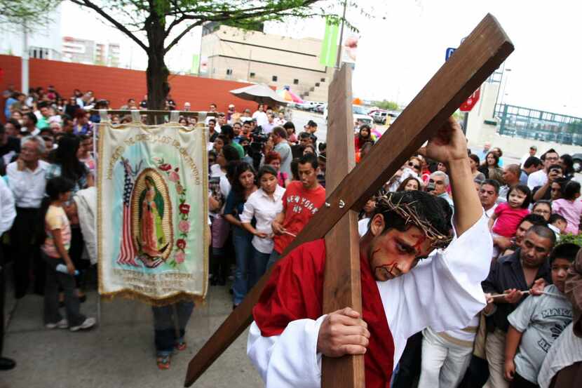 Uriel Jijon, right, plays the part of Christ in a representation of Christ walking the cross...