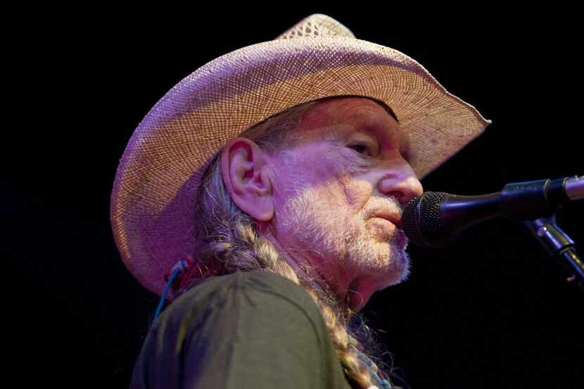 Willie Nelson sings and plays guitar during his headlining performance at Willie Nelson's...