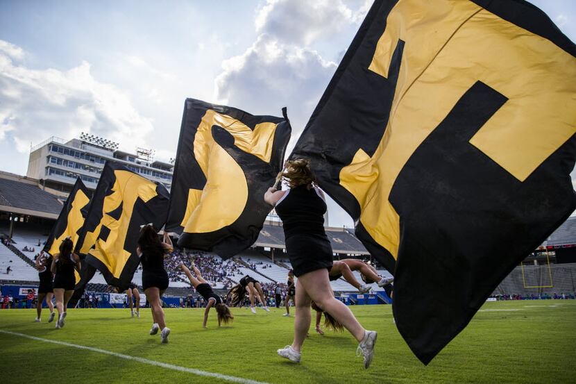 Plano East cheerleaders run flags along the end zone after a touchdown during the second...