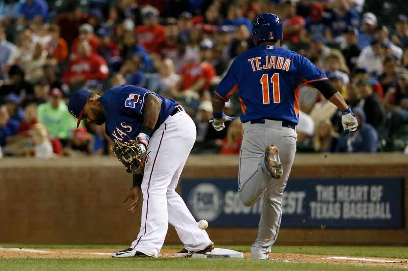 Texas Rangers first baseman Prince Fielder, left, is unable to catch a throw from third,...
