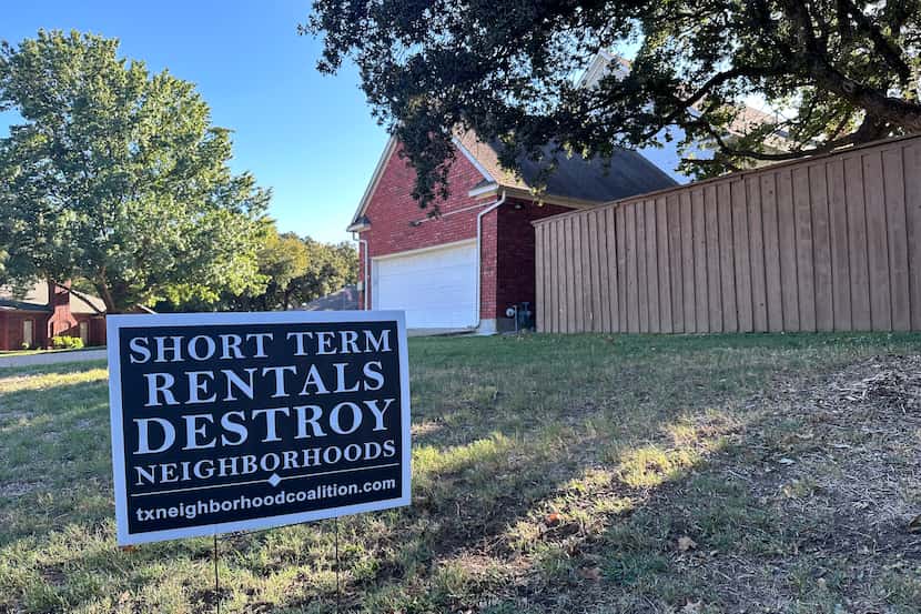 A sign showing opposition of short-term rental properties on the lawn of a STR property in...