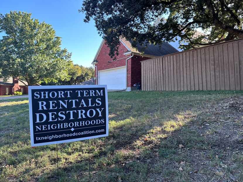 A sign showing opposition of short-term rental properties on the lawn of a STR property in...