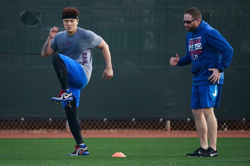 Texas Rangers outfielder Shin-Soo Choo does conditioning work in the outfield during a...