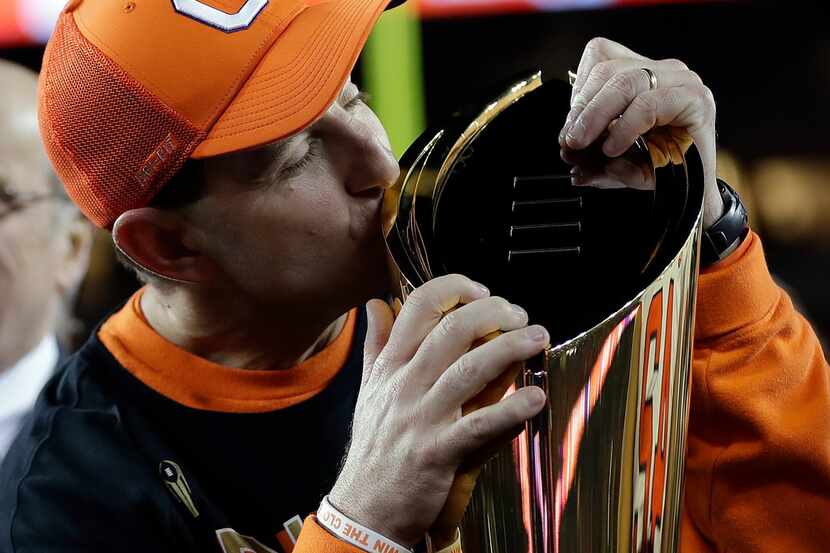 Clemson head coach Dabo Swinney kisses the championship trophy after the NCAA college...