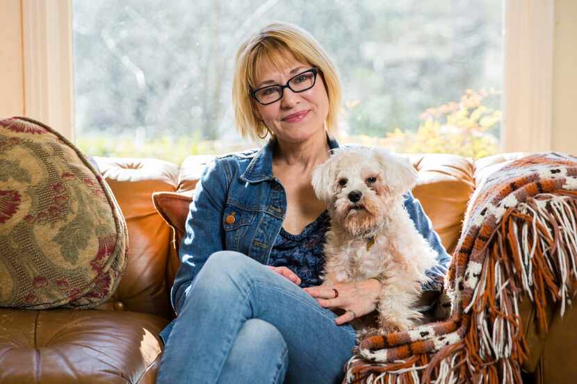 Author Elizabeth Crook poses for a portrait with her dog, Francis, in her living room on...