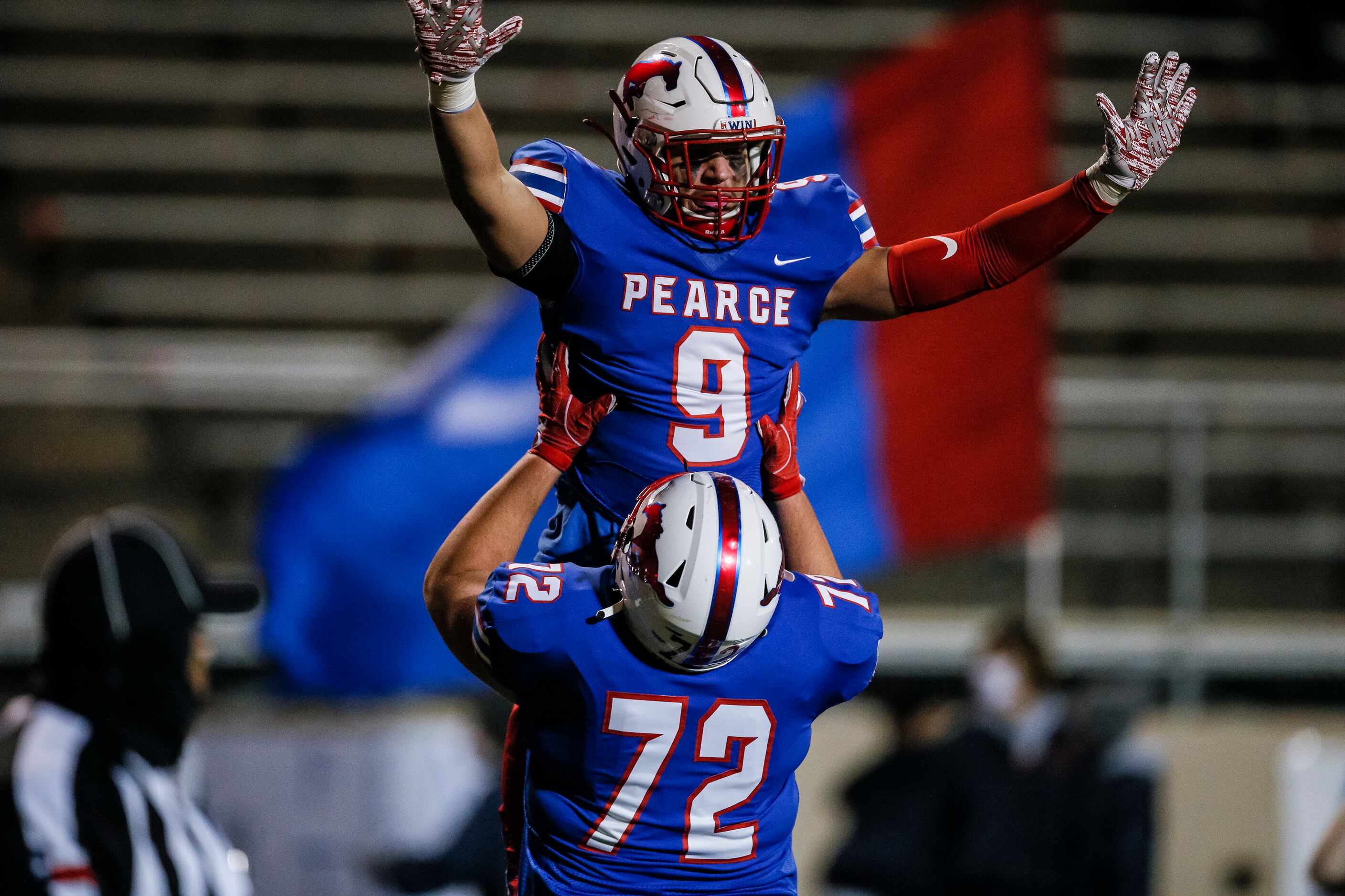 JJ Pearce senior halfback Dylan Adams (9) is lifted into the air by junior offensive lineman...