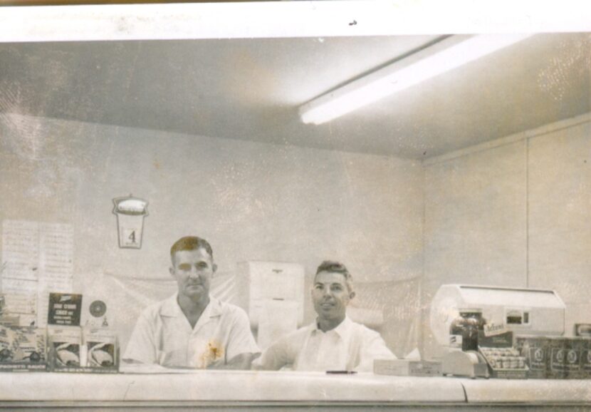 
Henry Francis, left, stands behind the deli counter with a butcher at his market.
