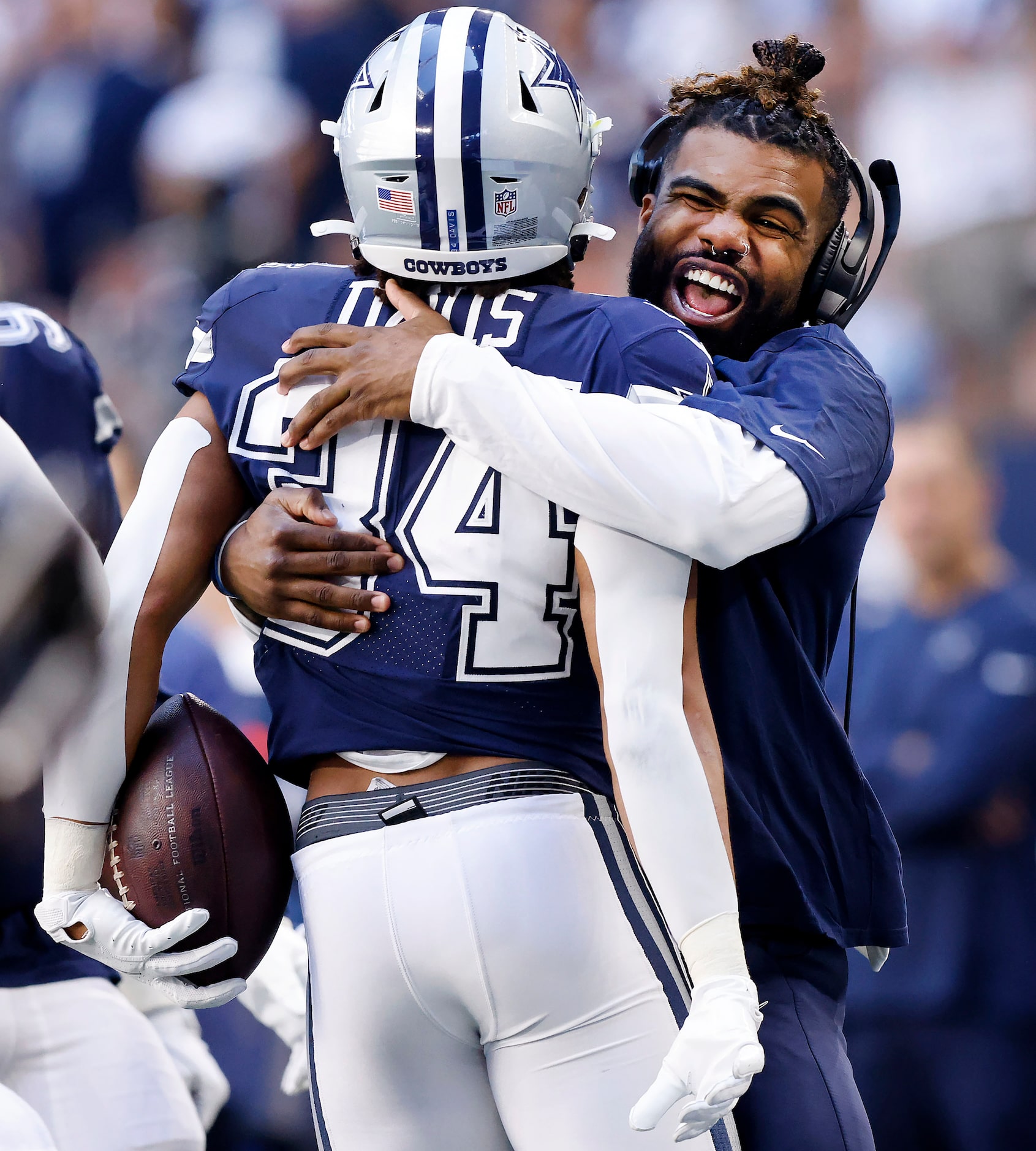 Injured Dallas Cowboys running back Ezekiel Elliott (right) hugs fellow running back Malik...